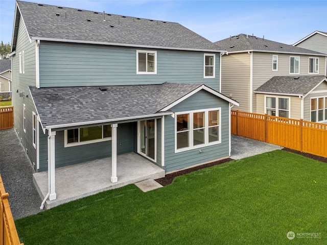 rear view of house with a patio and a lawn