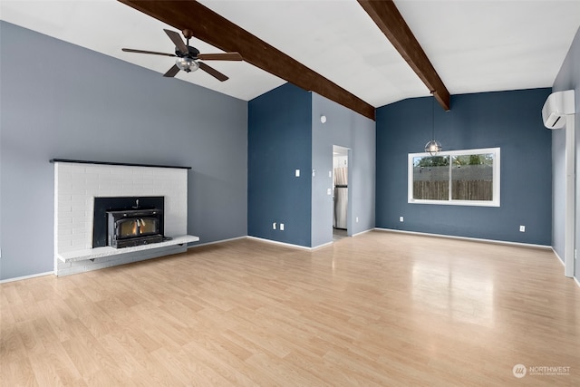 unfurnished living room with light wood-type flooring, a wall unit AC, ceiling fan, and a fireplace