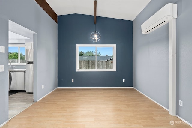 spare room with light wood-type flooring, lofted ceiling with beams, sink, and a wall mounted AC