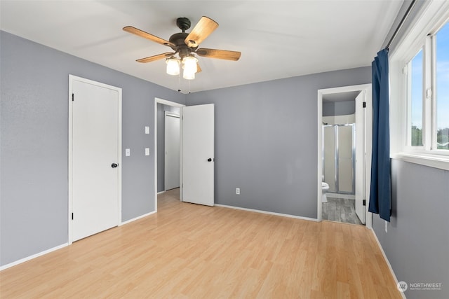 unfurnished bedroom featuring ceiling fan, light wood-type flooring, and ensuite bathroom