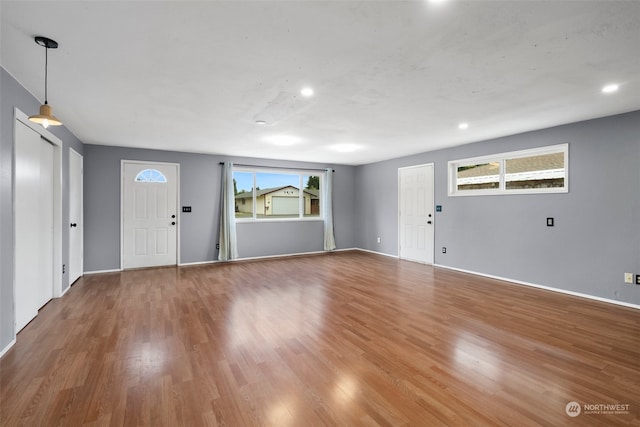 unfurnished living room with wood-type flooring and plenty of natural light