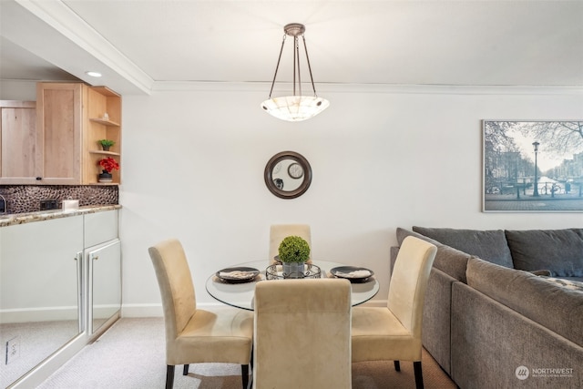 dining space with crown molding and light colored carpet