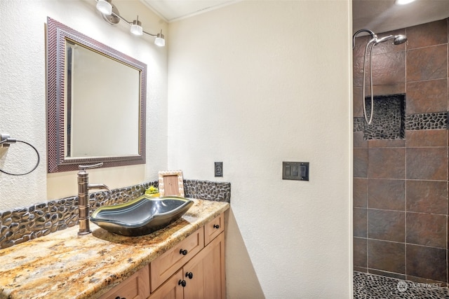 bathroom with vanity and a tile shower