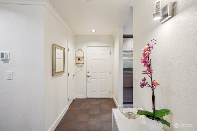 hall featuring ornamental molding and dark tile patterned floors