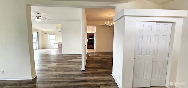 hall featuring dark wood-type flooring and a notable chandelier