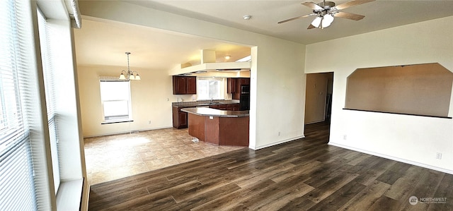 kitchen featuring ceiling fan with notable chandelier, dark brown cabinets, pendant lighting, and dark hardwood / wood-style flooring