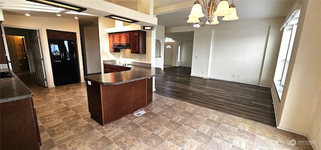 kitchen featuring dark hardwood / wood-style floors, kitchen peninsula, a kitchen bar, an inviting chandelier, and black appliances