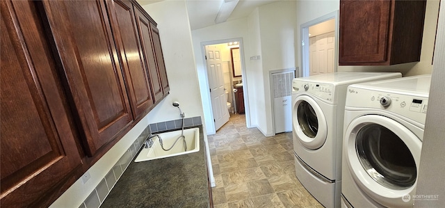 washroom with separate washer and dryer and cabinets