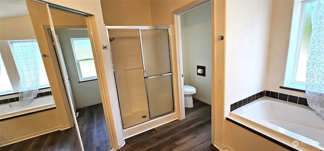 bathroom featuring wood-type flooring, toilet, and separate shower and tub