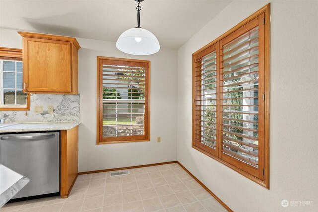 kitchen featuring dishwasher, decorative light fixtures, and a healthy amount of sunlight