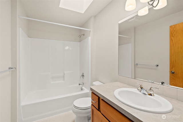 full bathroom featuring a skylight,  shower combination, vanity, and toilet