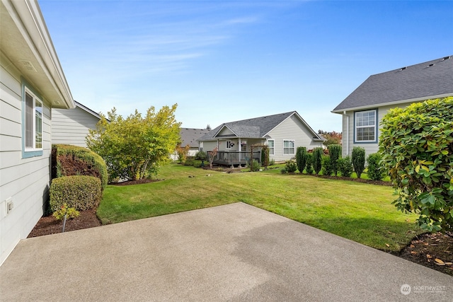 view of yard featuring a wooden deck and a patio area