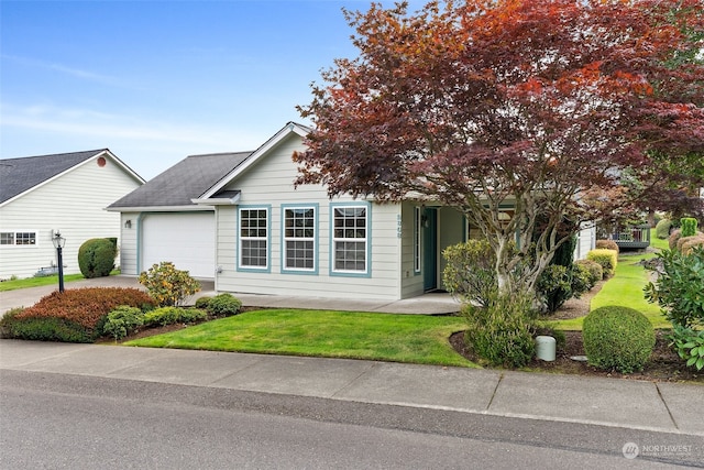 view of property hidden behind natural elements with a front yard and a garage