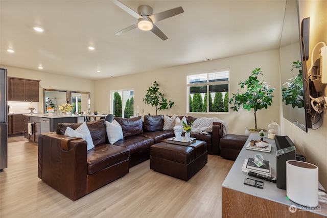 living room featuring ceiling fan, light hardwood / wood-style flooring, and a healthy amount of sunlight