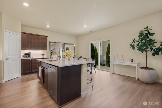 kitchen with dishwasher, light hardwood / wood-style flooring, sink, and an island with sink