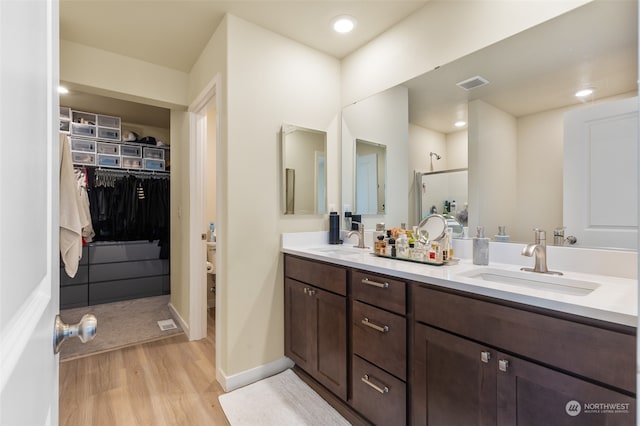 bathroom featuring vanity, a shower, and hardwood / wood-style floors