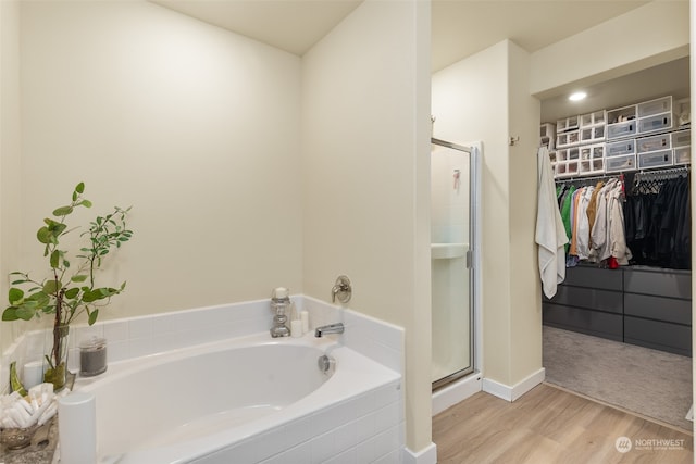 bathroom featuring wood-type flooring and independent shower and bath