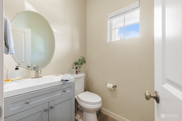 bathroom with hardwood / wood-style floors, vanity, and toilet