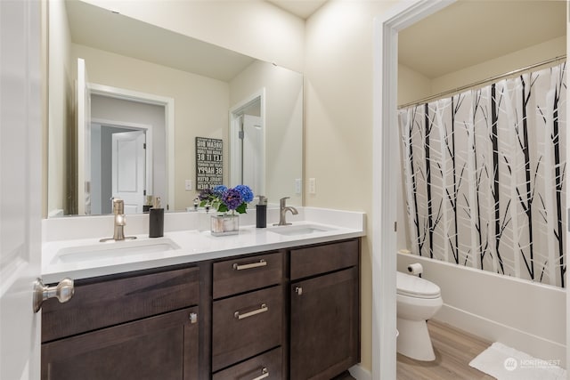 full bathroom with shower / tub combo, vanity, toilet, and hardwood / wood-style flooring