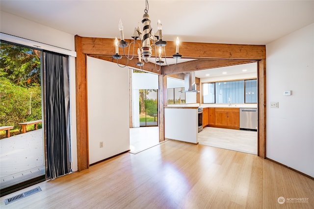 unfurnished dining area featuring an inviting chandelier and light hardwood / wood-style floors