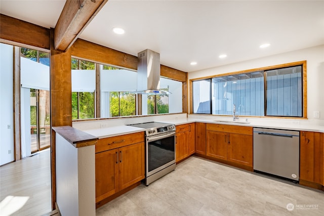 kitchen featuring stainless steel appliances, island range hood, beamed ceiling, and plenty of natural light