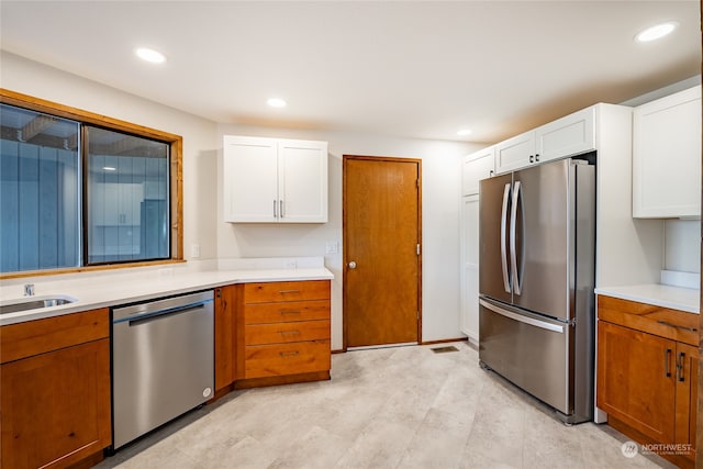 kitchen with stainless steel appliances, white cabinetry, and sink