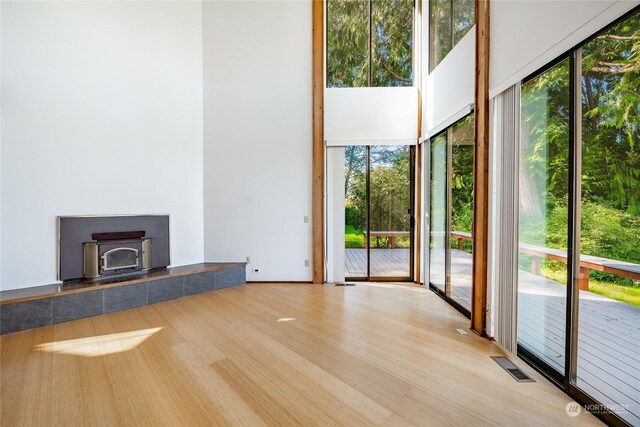 2879 N Nugent Rd Unit H8, Lummi Island, WA 98262 - unfurnished living room featuring a towering ceiling, a wood stove, and wood finished floors