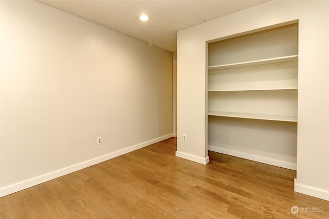 unfurnished bedroom with a textured ceiling and hardwood / wood-style floors