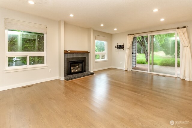 unfurnished living room with hardwood / wood-style flooring and a fireplace