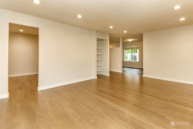 empty room featuring hardwood / wood-style flooring and a textured ceiling