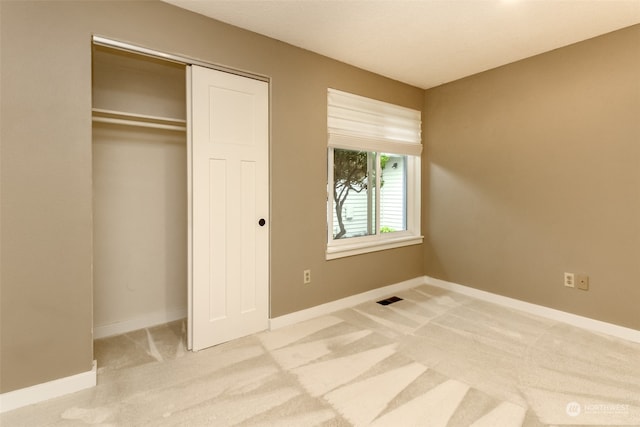 unfurnished bedroom featuring carpet floors and a closet