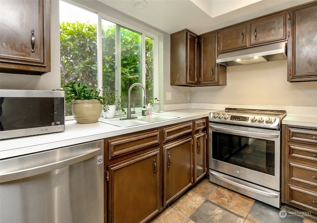 kitchen with appliances with stainless steel finishes, dark brown cabinetry, and sink