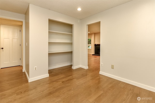 spare room featuring wood-type flooring and a textured ceiling