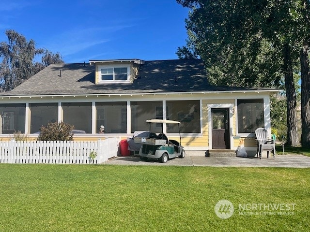 rear view of house with a yard and a sunroom