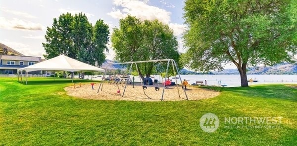 view of playground featuring a gazebo, a water view, and a yard