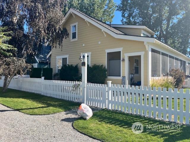117 Barefoot Ln E, Oroville, WA 98844 - view of front facade featuring a sunroom and a fenced front yard