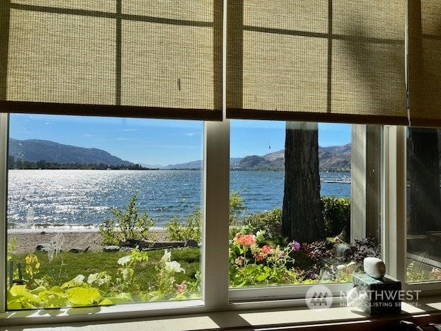 doorway to outside with a water and mountain view