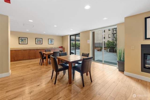 dining area featuring floor to ceiling windows and light hardwood / wood-style floors