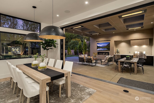 dining space featuring coffered ceiling and hardwood / wood-style flooring