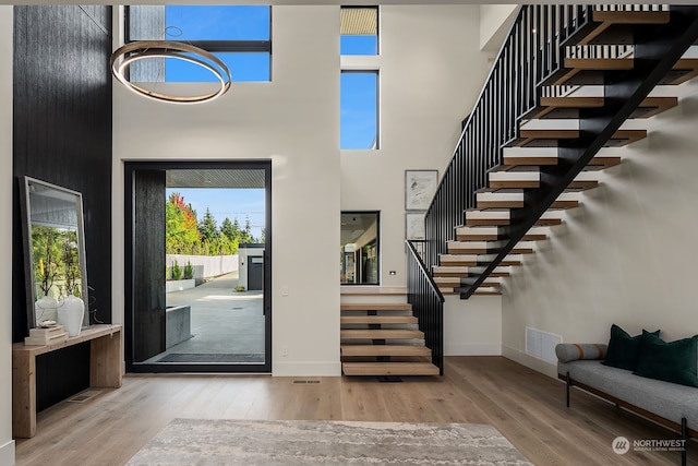 foyer entrance featuring hardwood / wood-style flooring and a high ceiling