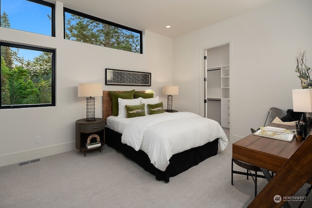 carpeted bedroom with a closet, a towering ceiling, and a spacious closet