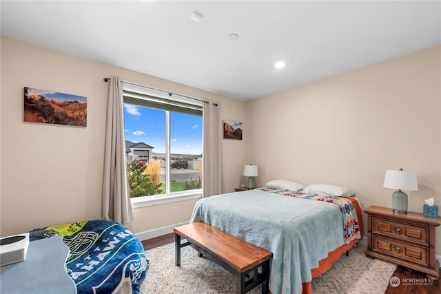 bedroom with baseboards and wood finished floors