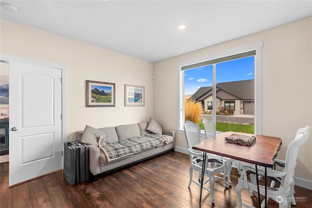 living room with baseboards and dark wood-style flooring