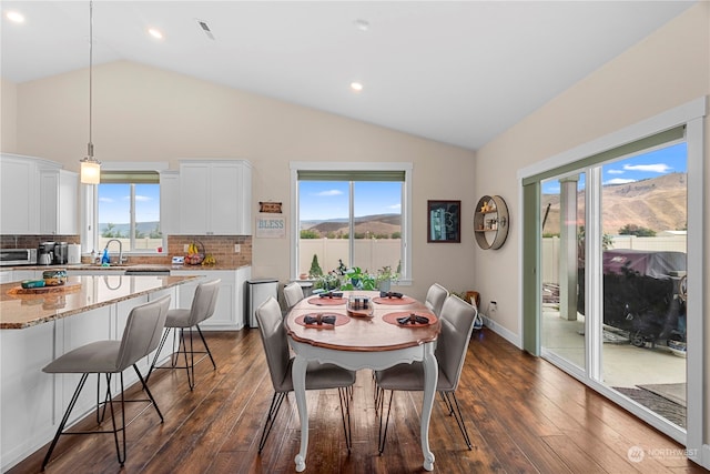 dining space with a healthy amount of sunlight, dark wood-type flooring, and vaulted ceiling