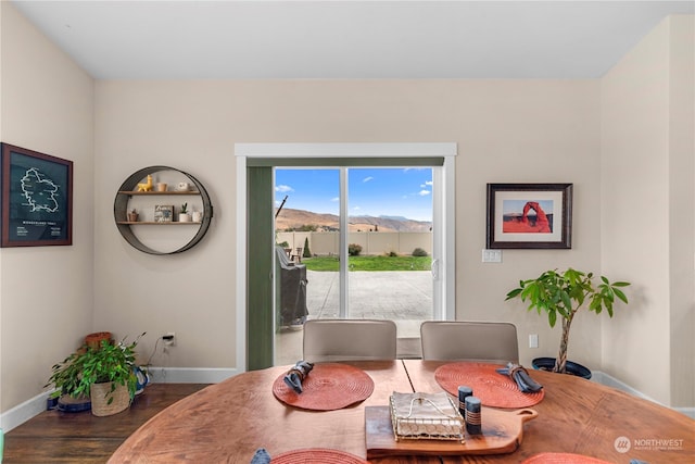 dining area with baseboards and wood finished floors