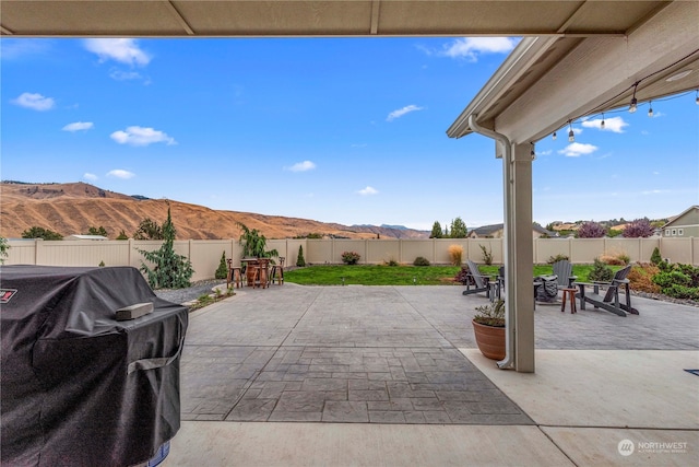 view of patio / terrace with area for grilling, a fenced backyard, and a mountain view