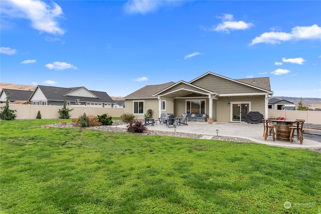 back of house with a patio, a lawn, and a fenced backyard