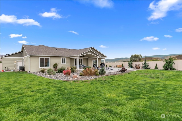 back of house featuring a patio, fence, central AC, a lawn, and a mountain view