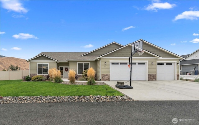 view of front of home featuring a garage, stone siding, a front lawn, and driveway