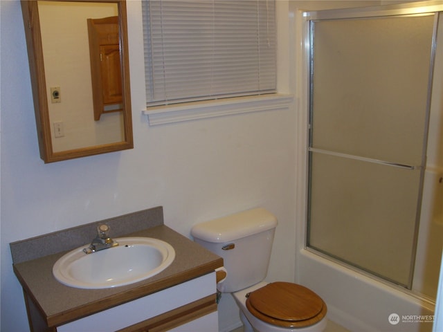 full bathroom featuring enclosed tub / shower combo, vanity, and toilet